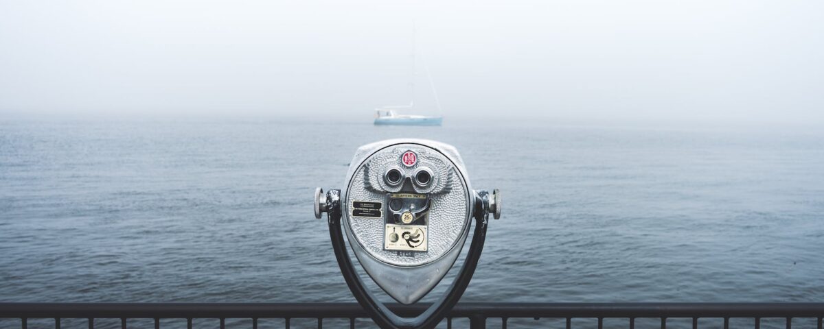 telescope in front of body of water
