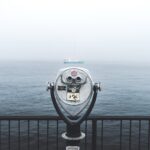 telescope in front of body of water