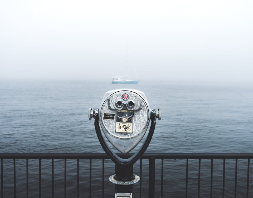 telescope in front of body of water