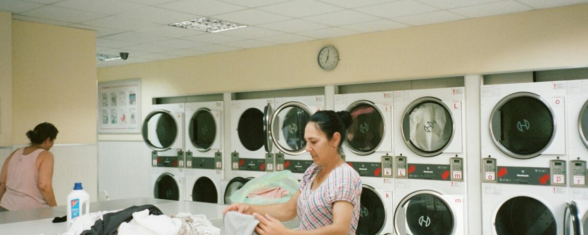 photo of woman standing inside the laundromat
