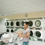 photo of woman standing inside the laundromat