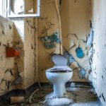 a damaged toilet inside an abandoned building