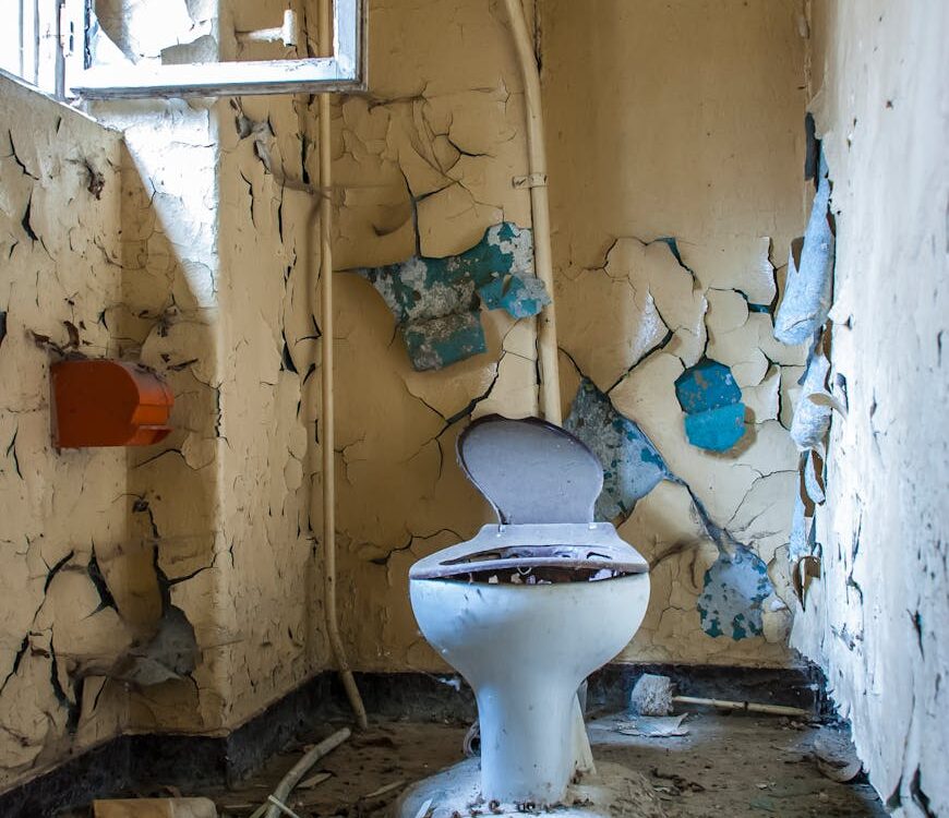 a damaged toilet inside an abandoned building